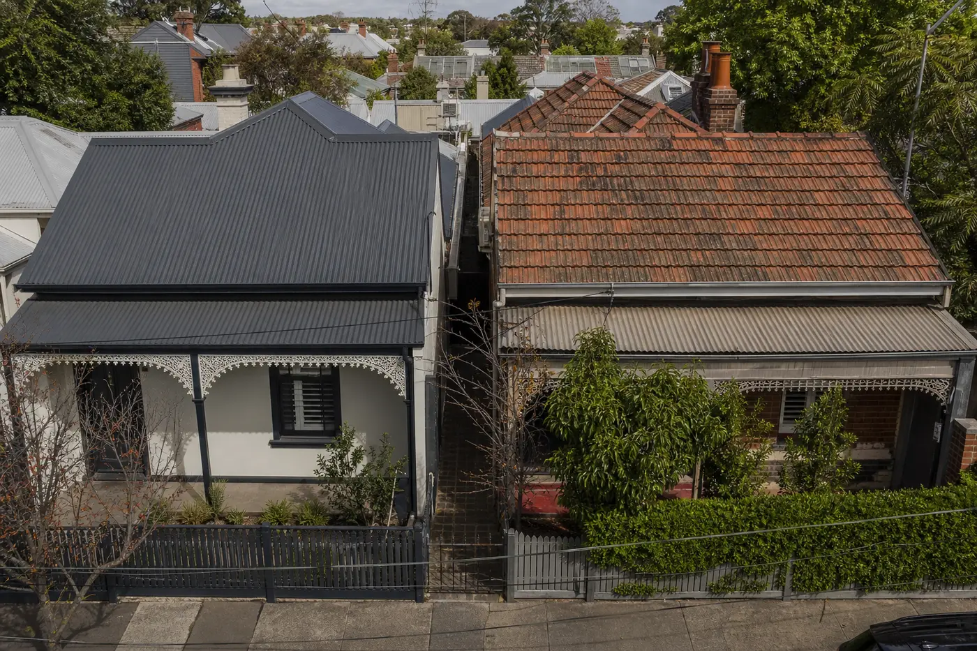A Colorbond metal roof and a terracotta tile roof side by side on two northern Melbourne homes