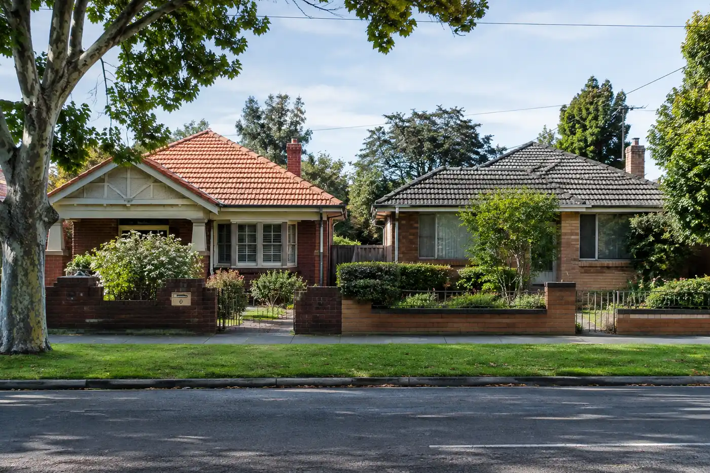 An orange terracotta tile roof and a grey concrete tile roof on neighbouring homes in Melbourne's northern suburbs