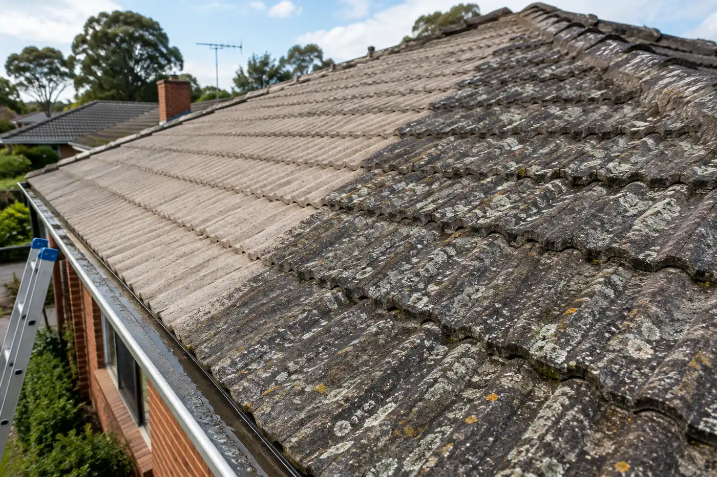 Faded concrete tile roof on a northern suburbs Melbourne home, partly cleaned of lichen