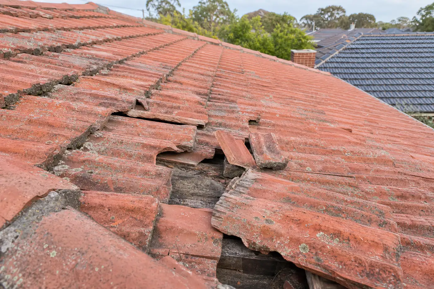 Cracked and slipped terracotta roof tiles after a storm on a northern Melbourne home